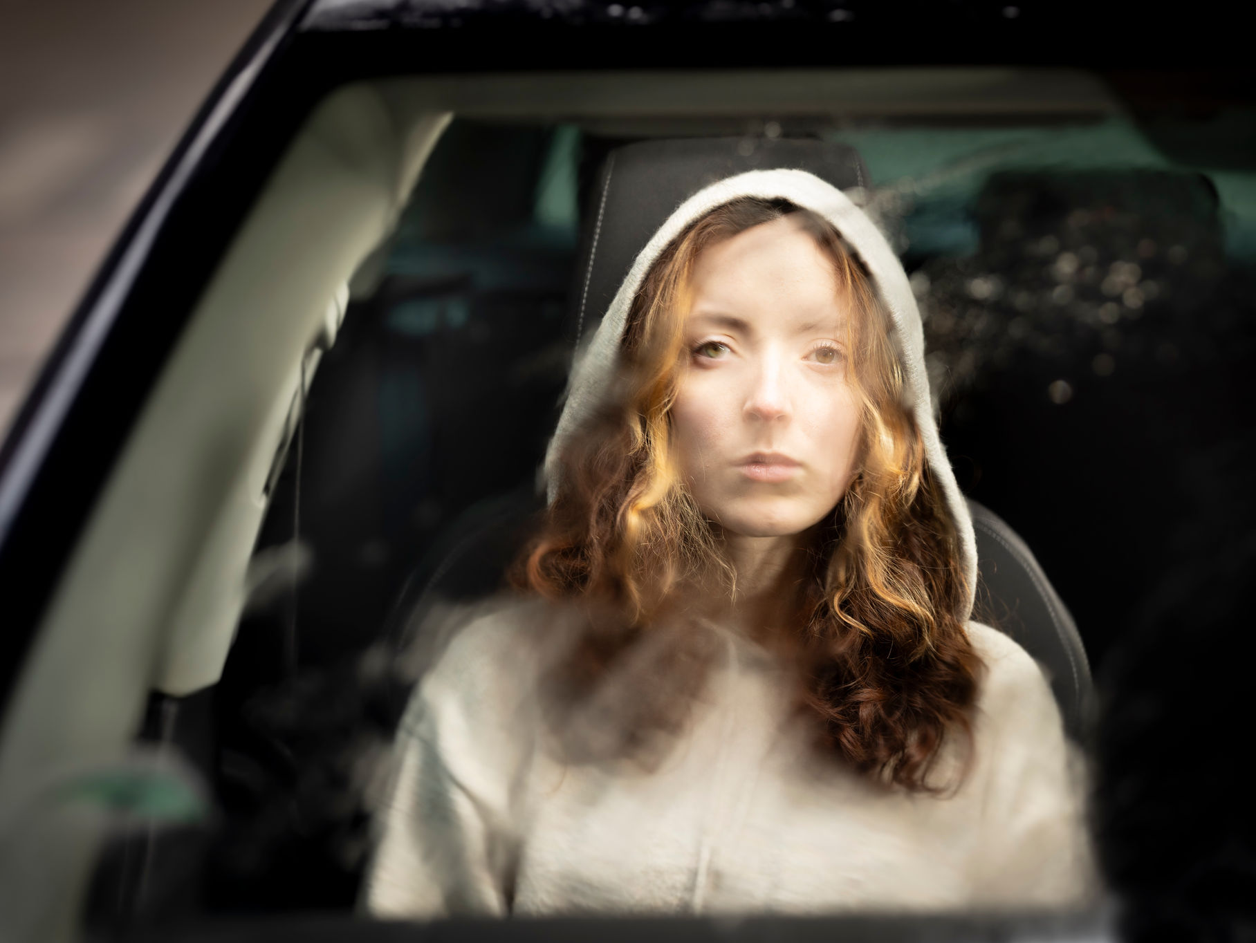 Jonge vrouw kijkt door het raam van een auto